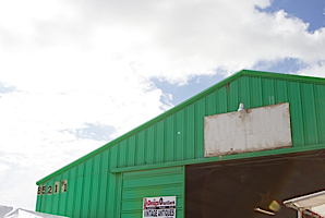 green flea market building with blue sky and clouds